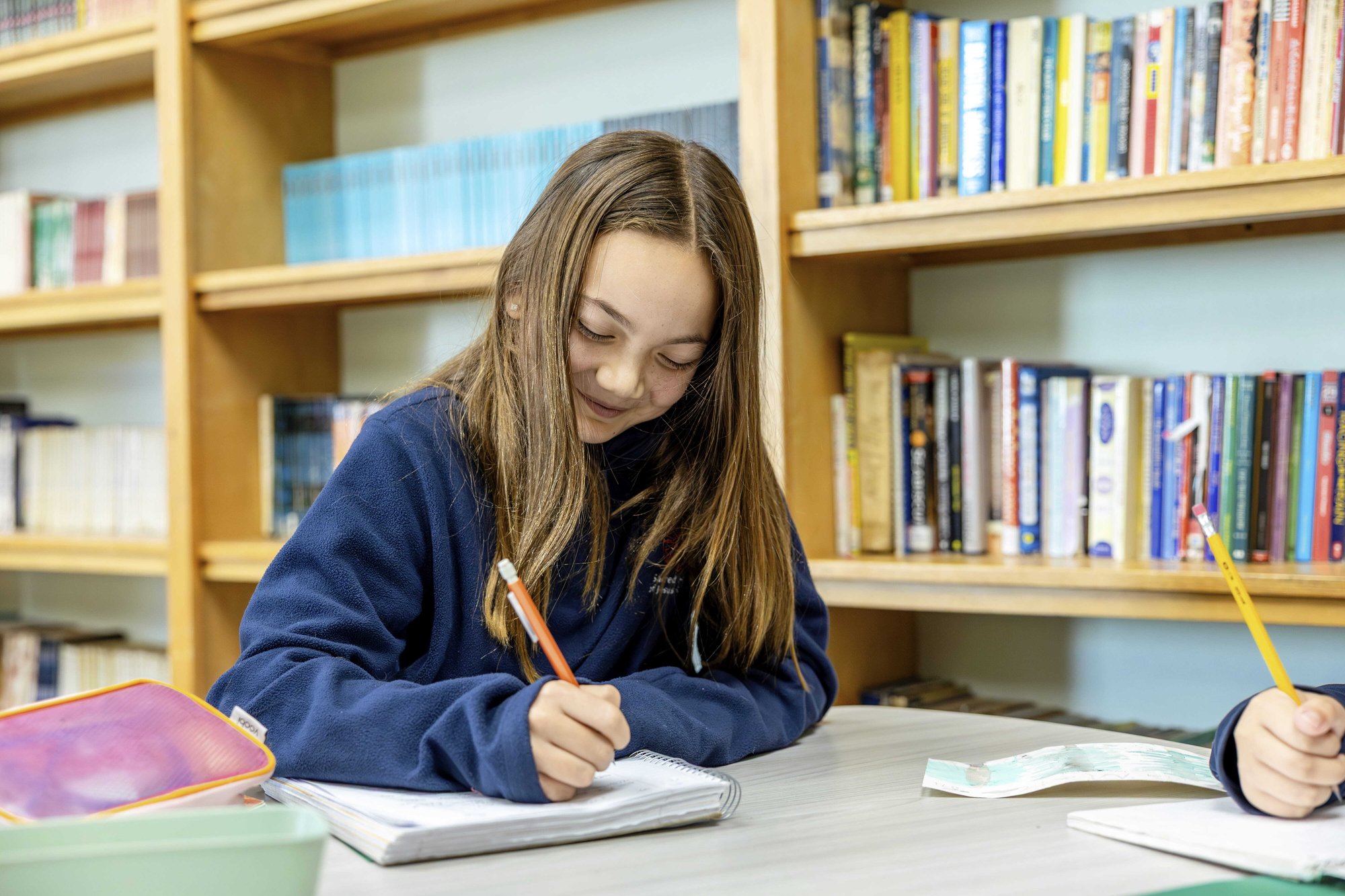 Student smiling while writing notes