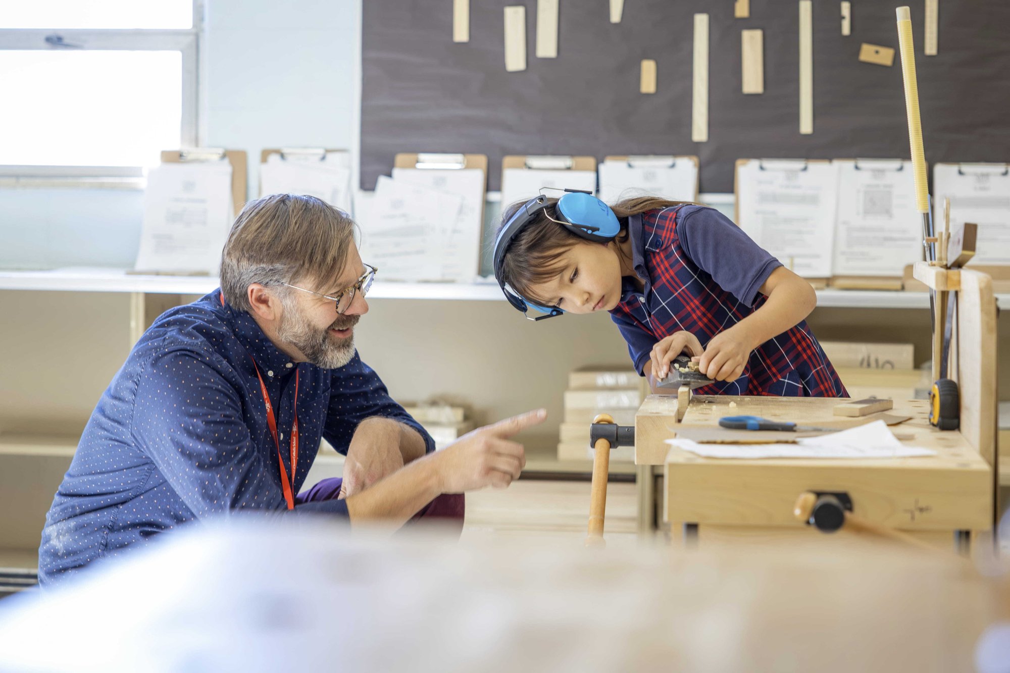 Teacher teaching woodwork with student